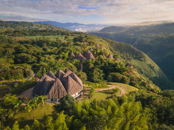 Aerial view of traditional thatched roof village in lush valley