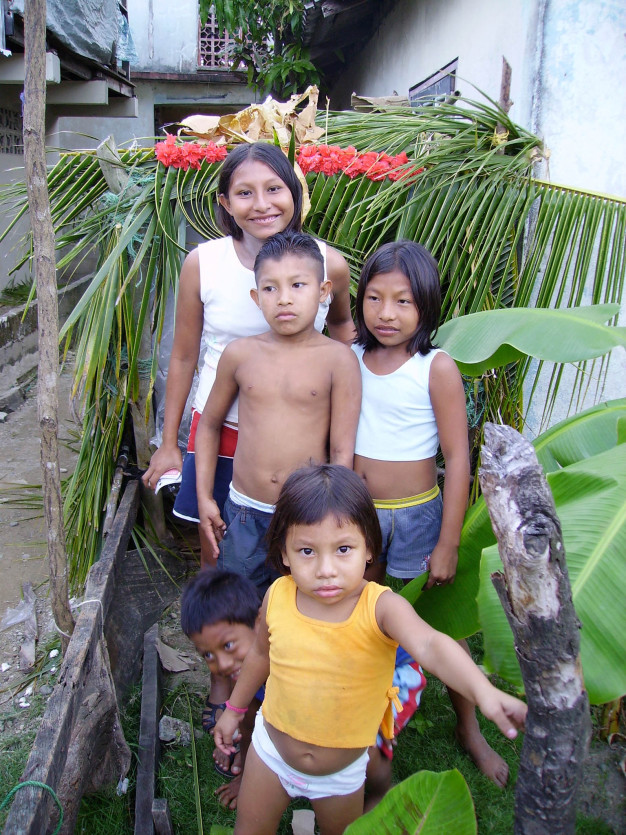 Groupe d'enfants entourés de plantes tropicales.