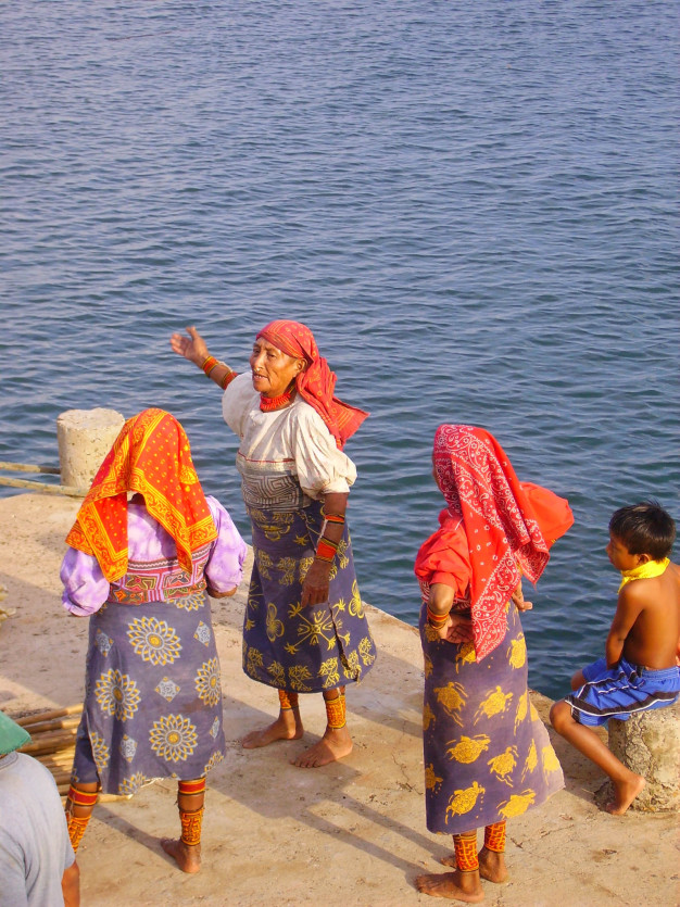 Femmes en tenue traditionnelle au bord de l'eau.