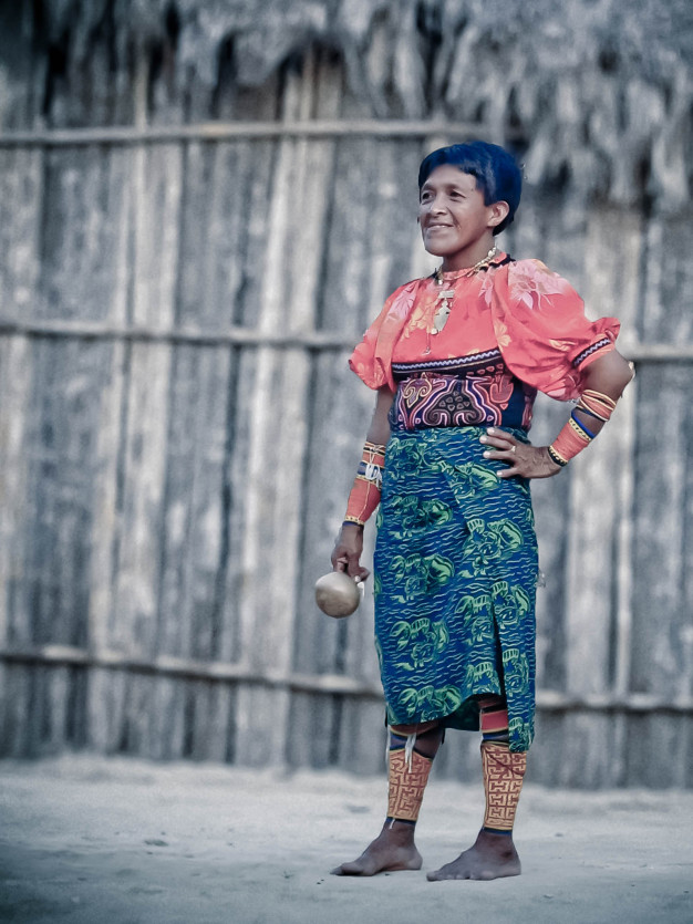Femme en tenue traditionnelle tenant une calebasse.