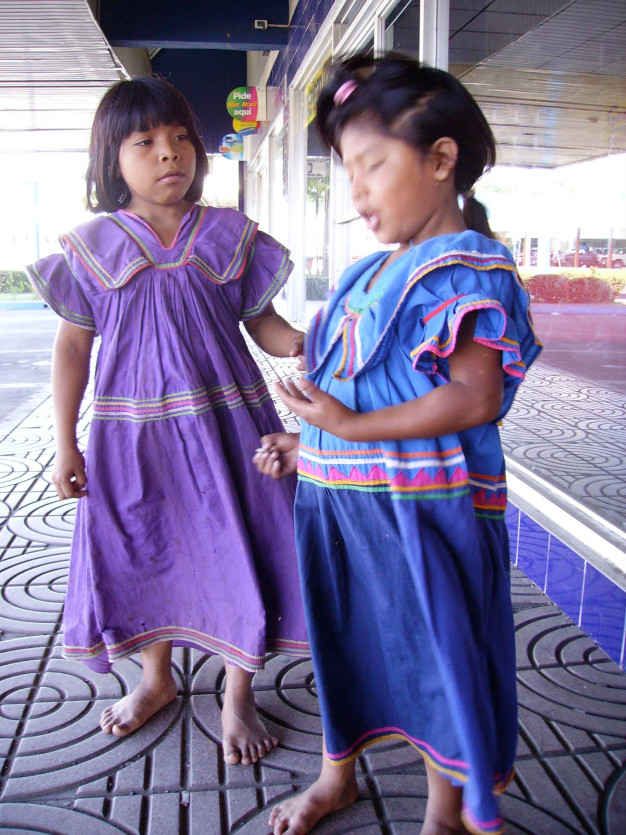 Deux filles en robes traditionnelles sur un trottoir