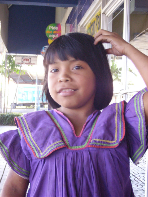 Jeune fille souriante en robe traditionnelle violette.