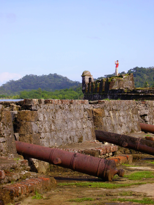 Personne se tenant près des canons historiques et des ruines de la forteresse.