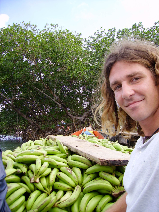 Homme avec des bananes sur un marché en plein air.