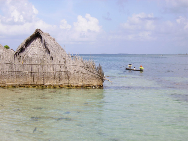 Cabane au toit de chaume et pêcheurs sur la mer tropicale.