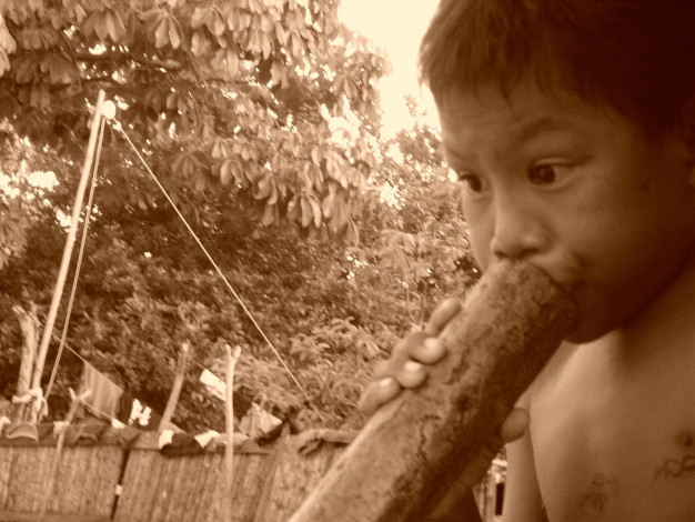Enfant jouant avec un bâton de bois en plein air