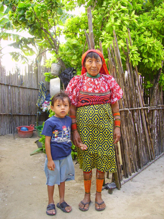 Femme et enfant en tenue traditionnelle à l'extérieur.