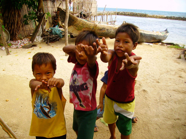 Enfants jouant sur une plage tropicale.