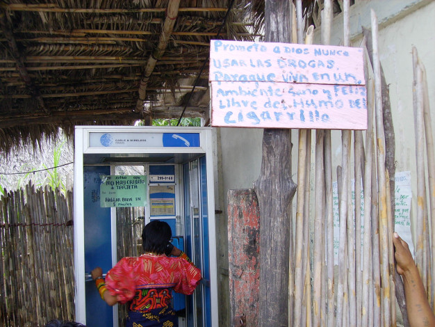 Personne utilisant une cabine téléphonique publique en milieu rural.