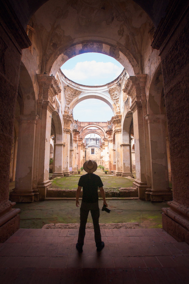 Person exploring ancient ruins under open sky.