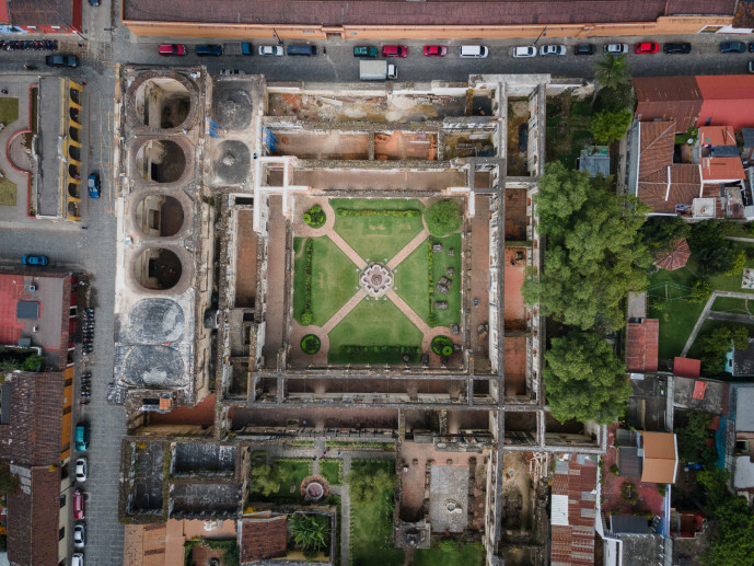 Vue aérienne d'un bâtiment historique en ruine avec jardin.