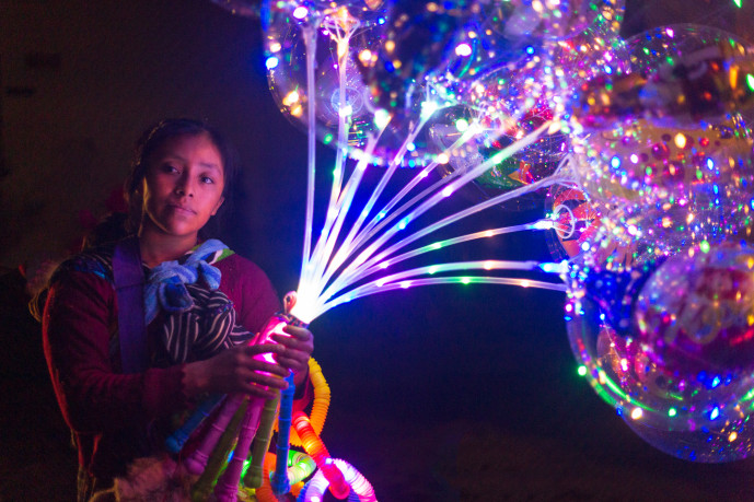 Femme vendant des jouets lumineux de nuit.