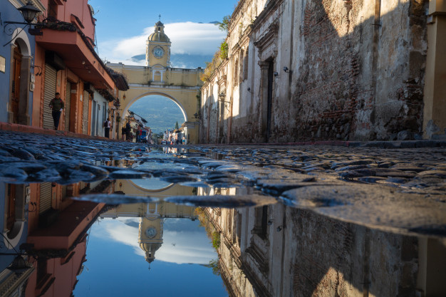 Historic street with arch reflection in puddle