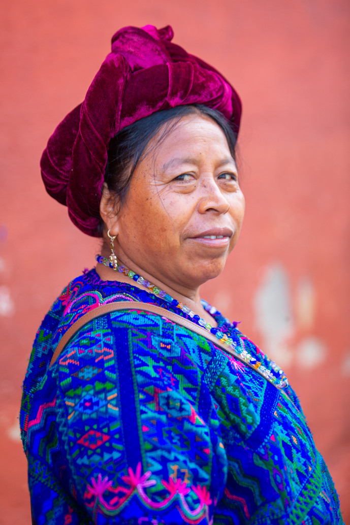 Femme en tenue traditionnelle avec un couvre-chef rouge.