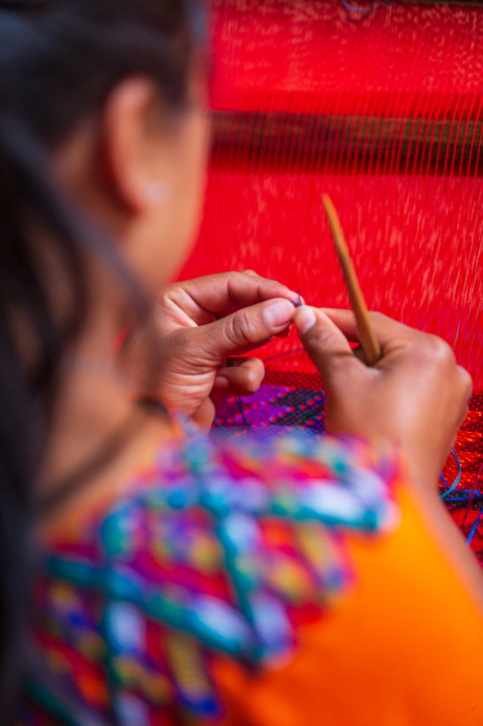 Tissage artisanal à la main sur un métier à tisser traditionnel.