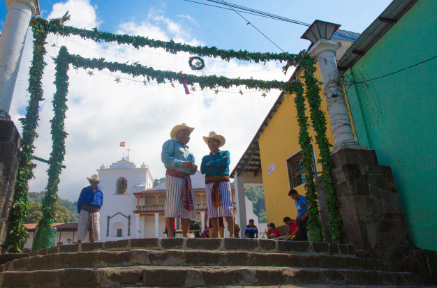 Traditional festival, men in cultural clothing, outdoor church plaza.