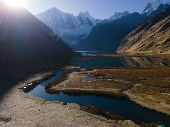 Sunrise over serene high-altitude mountain lake.