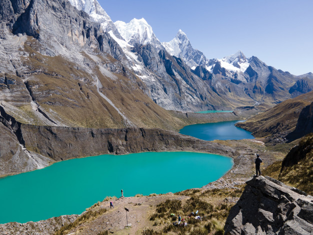 Mountainous landscape with vivid turquoise lakes and hikers.