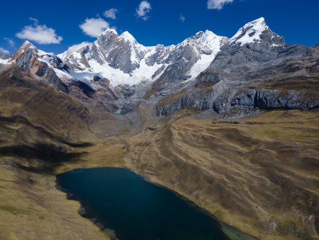 Montagnes enneigées au bord d'un lac alpin.