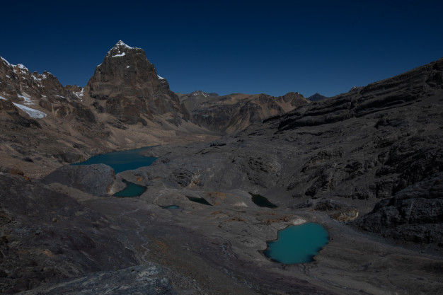 Terrain montagneux avec des lacs glaciaires de couleur turquoise.