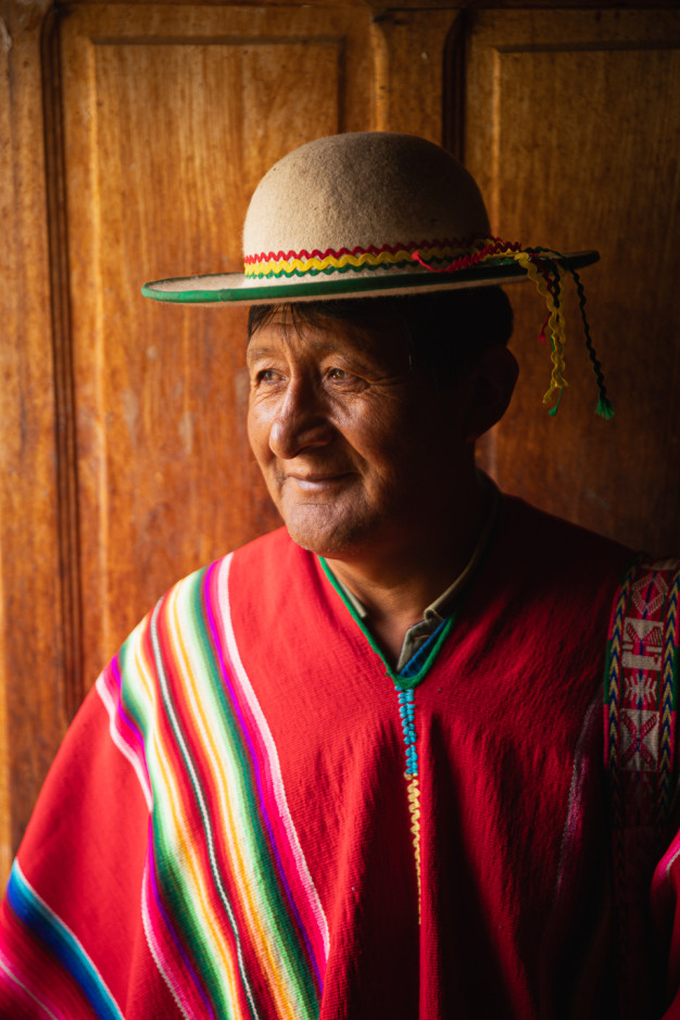 Man in traditional Andean clothing smiling.