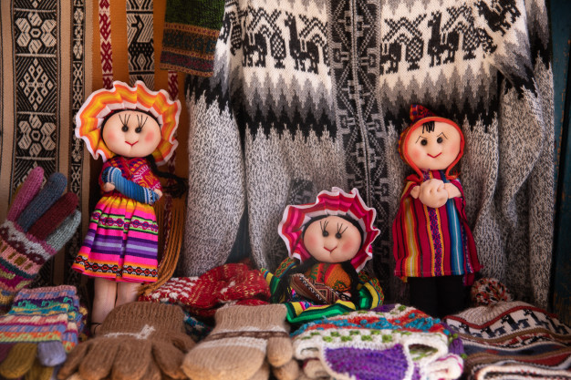 Poupées traditionnelles parmi les textiles faits à la main et les gants tricotés.