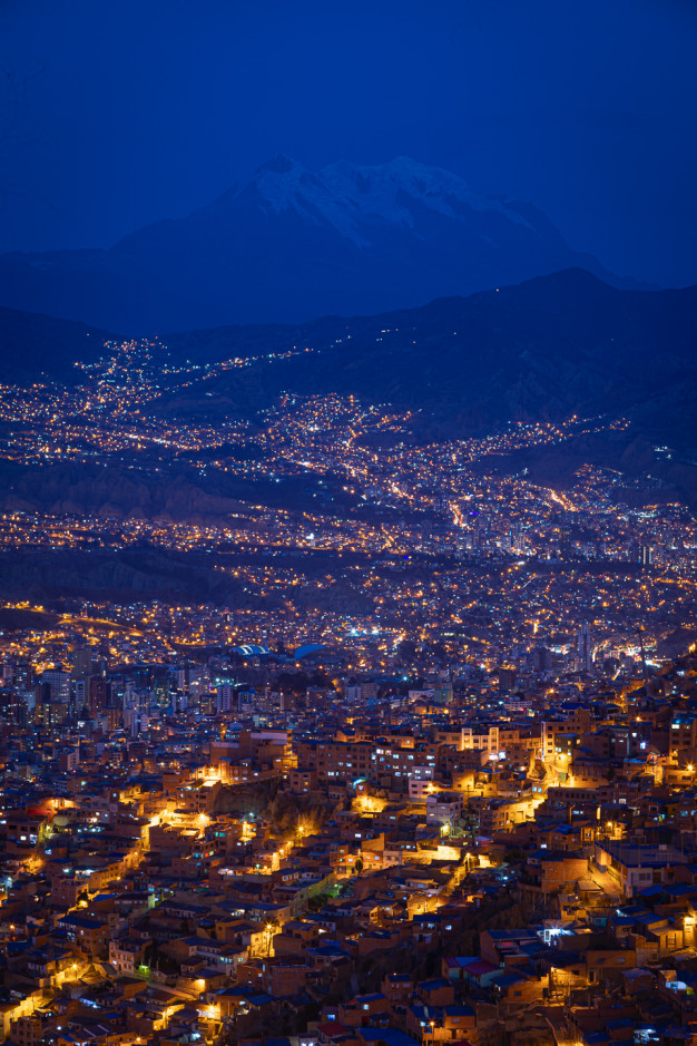 City lights at night with mountain background.
