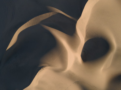 Vue aérienne de dunes de sable ondulées dans le désert.