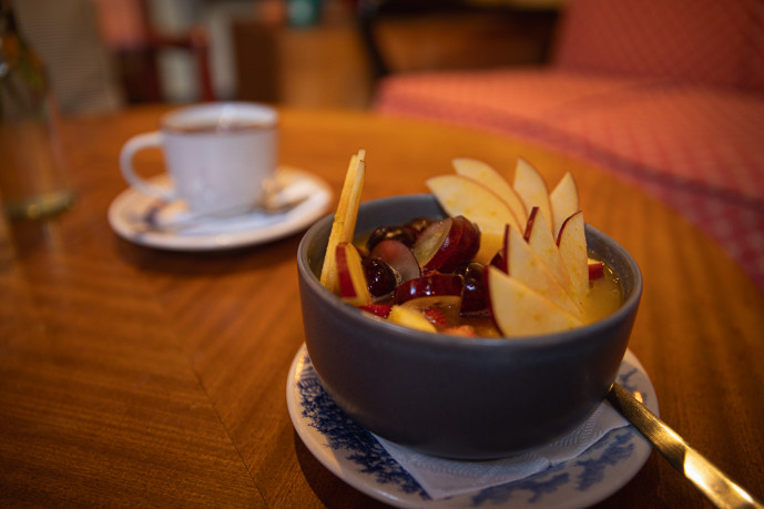 Fruit bowl and coffee cup on table.