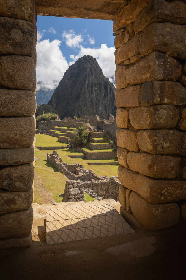 Machu Picchu view through ancient stone doorway.