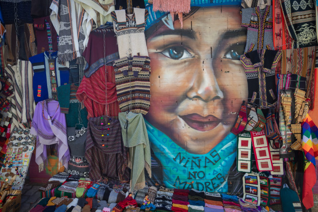 Colorful textiles surrounding mural of child's face.