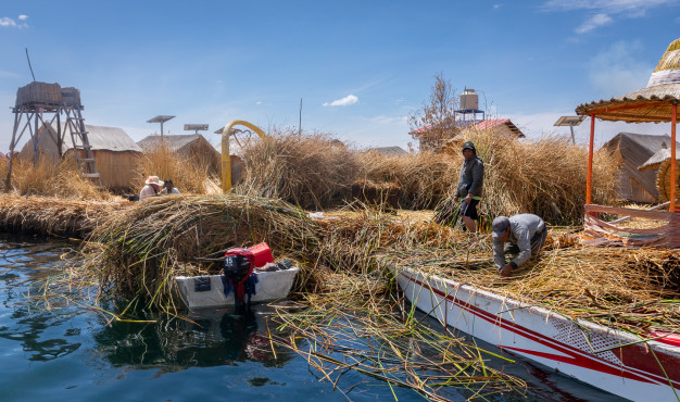 Floating reed islands with local inhabitants and boats.