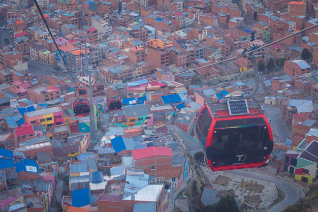 Aerial cable car over colorful urban area.