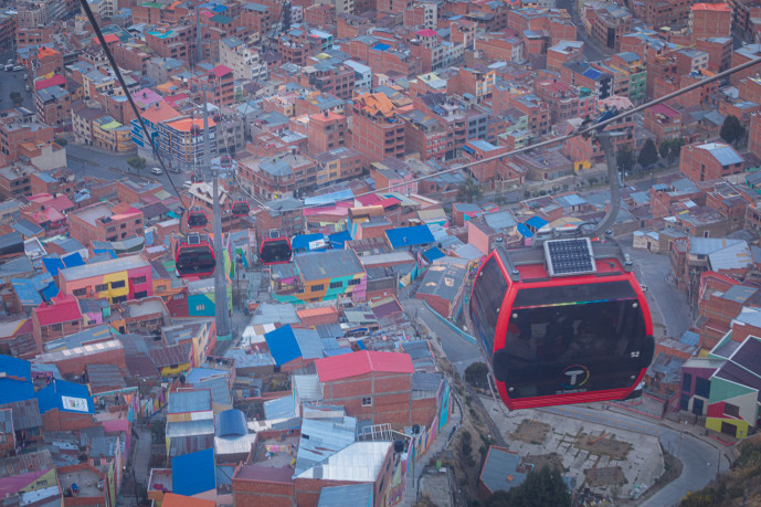 Aerial cable car over colorful urban area.