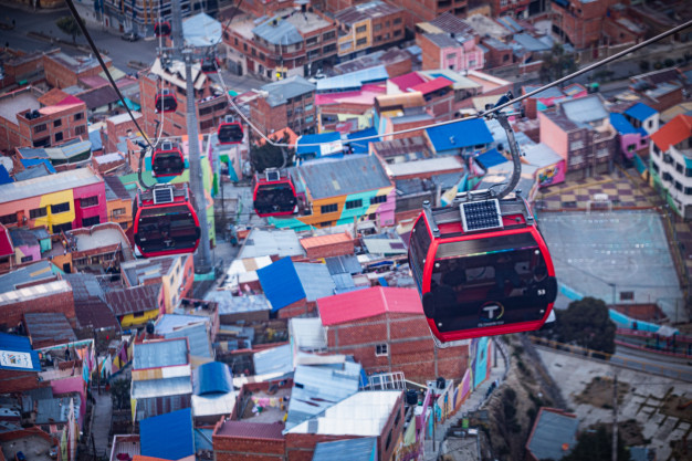 Cable cars over colorful urban neighborhood roofs