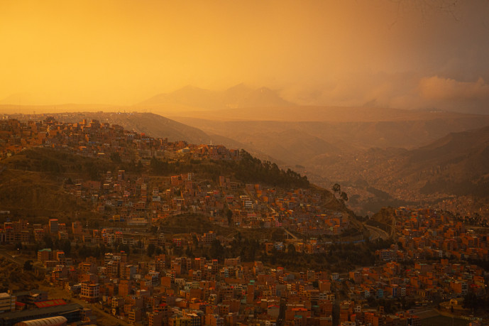 Sunset over hilly urban landscape.