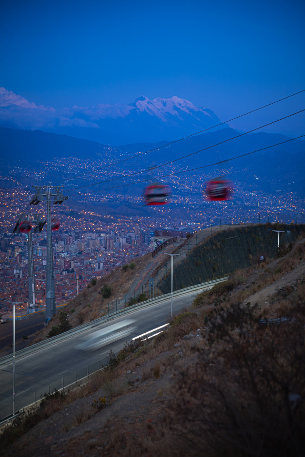 Paysage urbain au crépuscule avec les téléphériques et les montagnes en toile de fond.