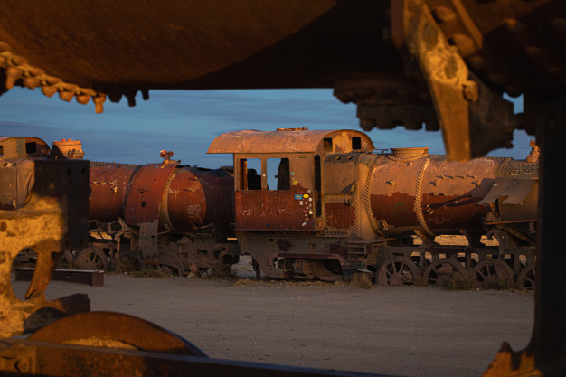 Rusty old trains at sunset in train graveyard.