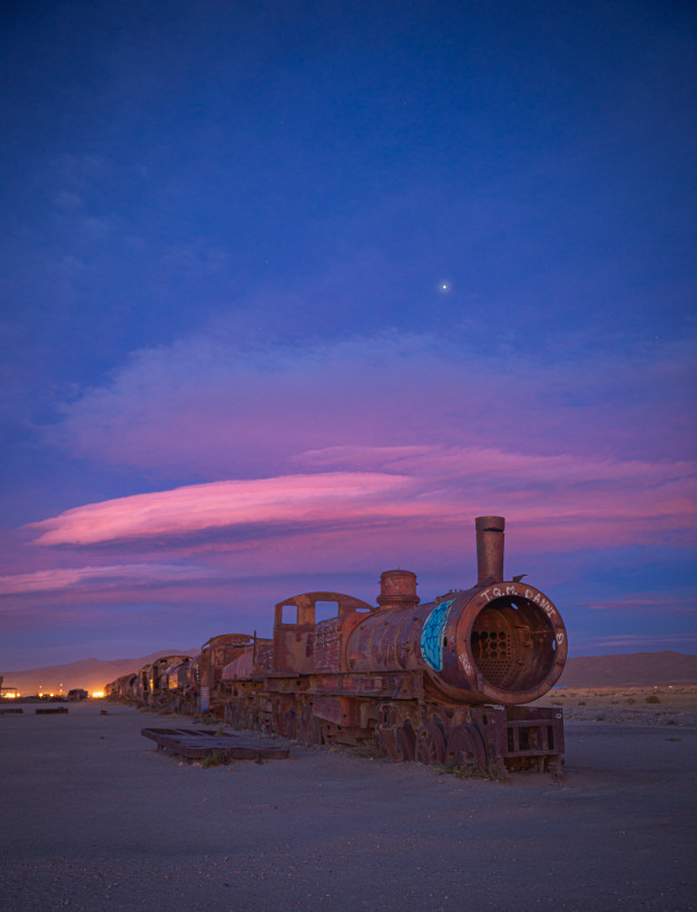 Abandoned train under twilight sky with star visible