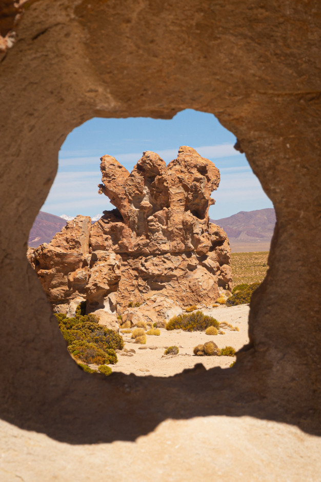 Formation rocheuse encadrée par une arche en pierre naturelle.