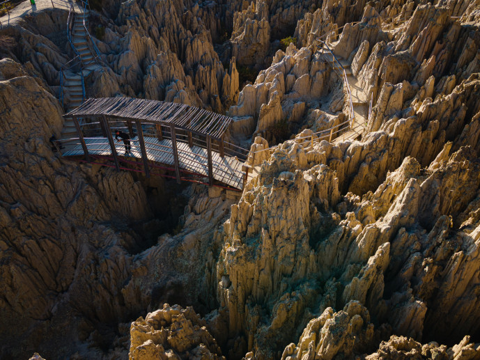 Wooden bridge over rugged canyon terrain.