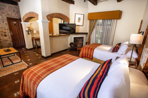 Elegant twin bedroom with fireplace and traditional decor.