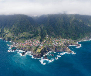 Aerial view of coastal village with cliffs and ocean.